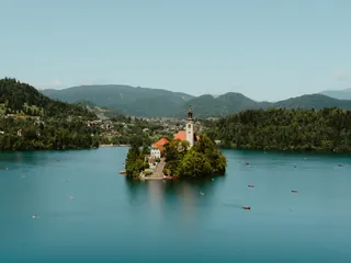 L’île du lac de Bled et son église, sur une eau turquoise entourée de collines boisées, en Slovénie.