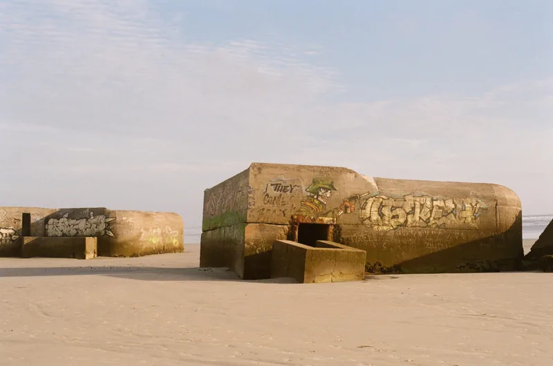 Des bunkers couverts de graffitis sur une plage de sable, photo sur pellicule.